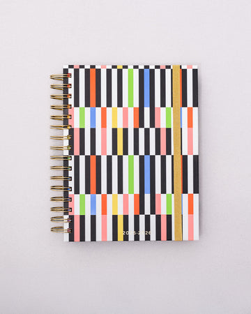 white medium 17-month planner with colorful scattered rectangle print and gold elastic closure